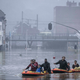 People use rubber rafts in floodwaters after the Meuse River broke its banks during heavy flooding in Liege, Belgium, Thursday, July 15.